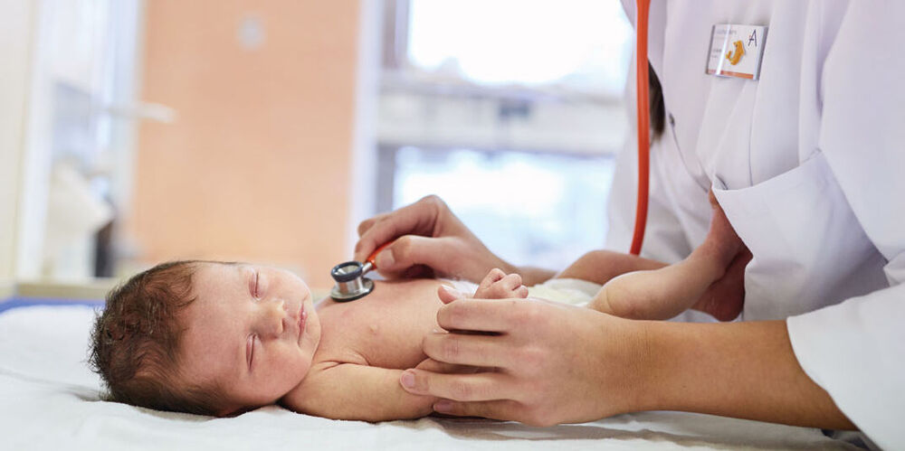 Eine Ärztin untersucht ein Neugeborenes.