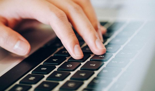 Eine Hand tippt auf einer Tastatur.